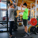 therapist helping young athlete in gym