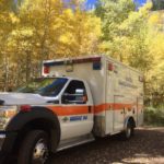ambulance parked by aspen trees