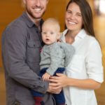 parents pose with their baby