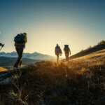 group of hikers walking at sunset