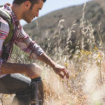 Side view of young man with backpack and water bottle hiking Elevate men's health