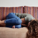 Woman Lying On Sofa, Suffering From Abdominal Pain what is endometriosis