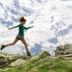 A woman hiking in the mountains. springing forward