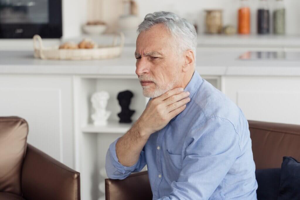 Sick mature aged man feeling throat