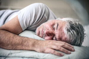 Senior man sleeping in bed. Space for copy.