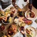 healthy meals holiday leftovers High angle view at diverse group of friends enjoying homemade food at festive dinner table with roasted turkey or chicken, copy space